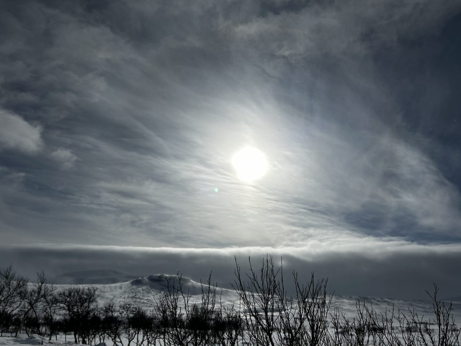 Vintersol over fjelde og dramatiske skyer